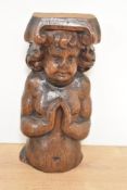 A 17th-century English Carved Oak Cherub, featuring tender features, gracefully clasped hands in