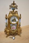 An early 20th-century French gilt metal mantel clock with painted Sevres-style porcelain