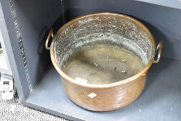 A large late 19th to early 20th century copper pot, with two handles and a turned rim, unmarked,