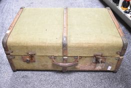 An early 20th century wood-framed suitcase, exterior lining in green canvas, measures 27 x 10 x 18