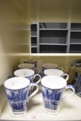 A set of seven Millennium Ringtons Fine Bone China beakers, illustrated in blue and white with