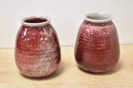 A pair of 20th-century Ruskin Pottery high-fired bud vases, of rounded form, featuring a deep
