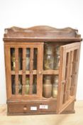 A late 20th-century wooden spice rack, with twelve apothecary-style labelled jars and stoppers,