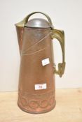 A late 19th-century German Jugendstil/ Art Nouveau brass and copper pitcher, featuring a brass-