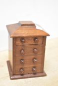 A late 19th-century apprentice piece miniature wooden desktop tallboy, to include three faux drawers