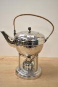 A 20th-century Arts and Crafts-style hammered metal spirit kettle on a warming stand, featuring a