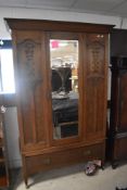 A Victorian oak mirror door wardrobe, having carved Art Nouveau style decoration and drawer to base,