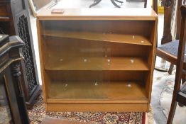 A vintage golden oak glazed low bookcase of slope form, width approx. 91cm