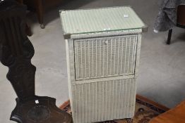 A vintage Lloyd Loom linen basket having flap opening to fronr and glass top, dimensions approx. H70