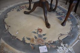 A modern Chinese rug of circular form having cream ground and blue border with foliate design,