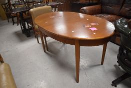 A vintage teak oval extending dining table in the G plan style, having butterfly style extension