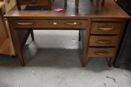 An early 20th Century oak desk, having frieze drawer and three side drawers with slide over,
