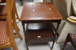 A reproduction mahogany etage style occasional table having turned frame and brass castors, width