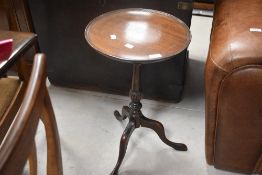 An earky 20th Century mahogany wine table having circular lipped top, diameter approx. 37cm (some