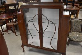 An early 20th Century mahogany china cabinet in the art deco style , having short shaped legs