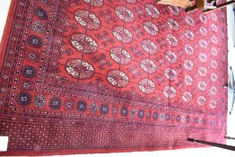 A Bokhara style rug having red ground and medallion decoration, approx. 344 x 247cm
