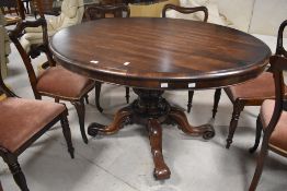 A Victorian rosewood/mahogany dining table having oval top, with tilt top mechanism on bulbous