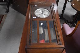 An early 20th Century oak cased wall clock having silvered dial with Arabic numerals
