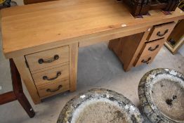 A modern golden oak dressing table or desk having drawers to right side, faux drawer cupboard to