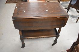 A vintage oak drop leaf teak trolley in the Priory style, approx. 68 x 42cm