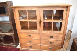 A vintage display cabinet having glazed section over six drawers, with campaign style handles ,