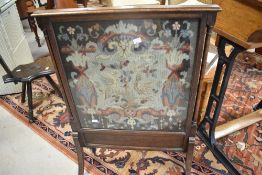 An early 20th century oak needlework panel firescreen with outswept legs and slender columns 83cm