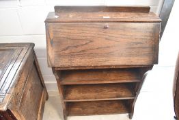 An early 20th Century oak bureau of slim form with open bookshelves , dimensions approx. H95 W67cm