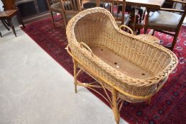 A vintage wicker moses basket on stand