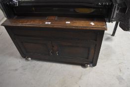 An early 20th Century oak bedding box of small proportions having left lid and doors to front, width