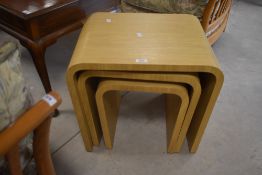 A modern laminate beech effect nest of tables of stylised form