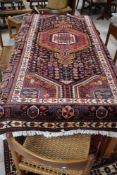A large Persian rug having bright and vibrant coloured design, approx. 240 x 130cm