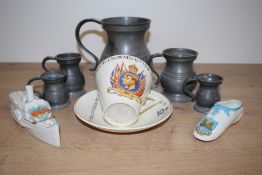 A large barrel shaped pewter tankard sold along with four similar smaller, a Shelley Bowness motto