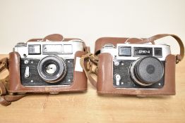 Two FED-4 35mm rangefinder cameras, both with FED 53mm f2.8 lens and brown leather case and strap.
