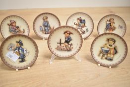 Seven miniature Hummel display plates by Goebel Germany 8.5cm diameter.