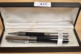 A boxed black and chrome ballpoint and rollerball pen set