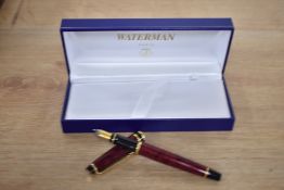 A boxed Waterman Expert converter fill fountain pen in Flame Red with gold trim having a Waterman