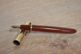 A Parker VP button fill fountain pen in Rust with a Rolled Gold cap having a Parker USA nib