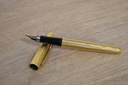 A Parker 75 converter fill fountain pen in gold Grain d'Orge pattern having Parker 585 France nib