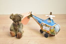 A late 19th to early 20th-century miniature automaton teddy bear, presumed mohair, wearing tiny