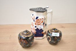 A pair of small Chinese cloisonné enamel lidded jars raised on tripod feet sold together with a