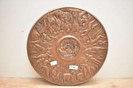 A heavy copper effect plaque depicting the Feast of Bacchus, measures 32cm across.