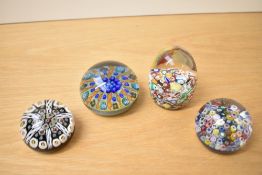 A group of four glass paperweights, comprising a domed scrambled millefiori weight, unsigned, two