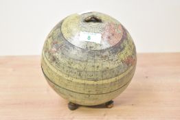 An early 20th century tin in the form of a terrestrial globe, the spherical body with printed map