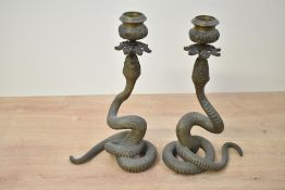 A pair of Victorian brass serpent chambersticks, each of coiled textured form with foliate