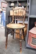 A Victorian elm spindle-back chair, featuring a star-design seat and floral decoration on the