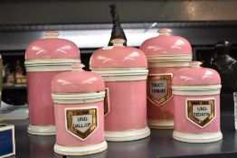 A group of five Victorian gilt embellished puce pottery apothecary/chemist jars, two large, one
