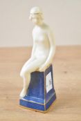 An Art Deco-style Royal Worcester china female nude figurine, depicted taking off her shoes while