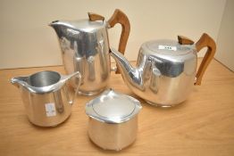 A mid 20th-century magnailium Picquot Ware tea set, featuring sycamore wood handles, to include milk