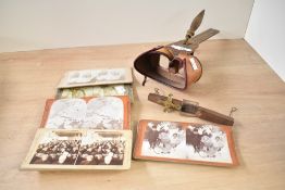 A Victorian wooden stereoscopic viewer with a collection of paired photographs, viewer of turned