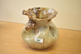 A 20th century studio pottery stoneware vase, formed as a loosely tied sack with mottled buff glaze,